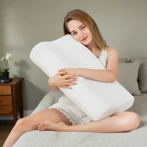 Happy woman cuddling white orthopedic memory foam pillow on bed, perfect for stress relief and deep sleep
