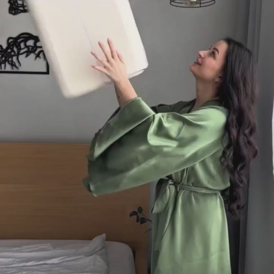 Close-up of hand pressing into white memory foam pillow core to show its softness and contouring effect. Demonstrates high-quality material for neck and spine support.